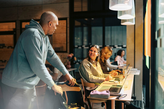 Diverse business colleagues interacting with each other at workspace