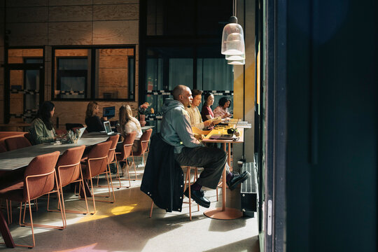 Diverse business professionals working in relaxed and collaborative atmosphere at coworking office hub