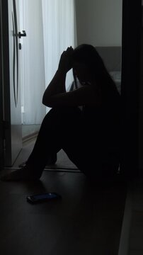Broken hearted woman sitting alone in dark room after breakup. Vertical video