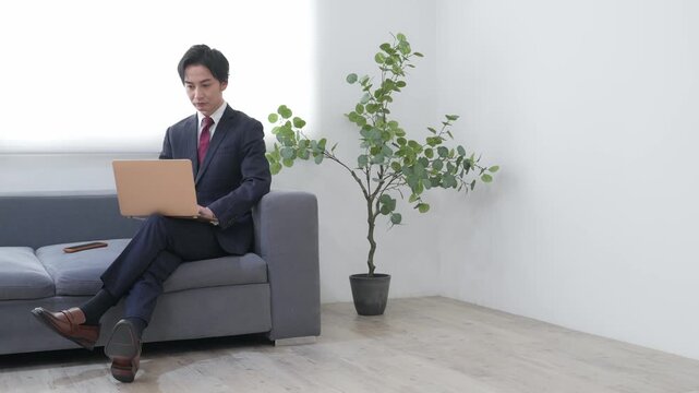 オフィスでノートパソコンを使う男性ビジネスパーソン