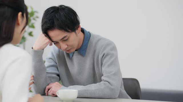 部屋で落ち込む男女カップル