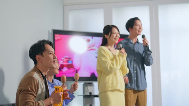 カラオケボックスで歌う男女グループ