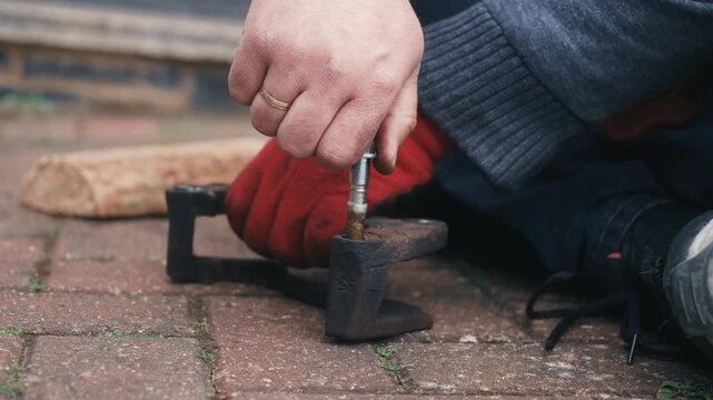 Installing lubricated brake caliper guide pin into caliper bracket during maintenance. DIY automotive repair ensuring proper brake component movement after lubrication. Close up vehicle servicing