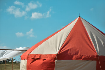 Red and white festival tent against a blue sky © Pawparazzi