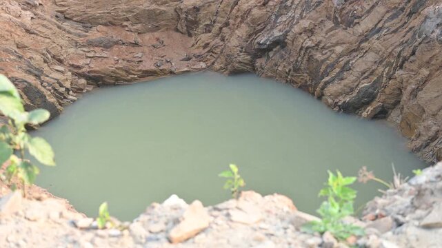 A well that has caved in during the rains.
It is filled with muddy water. This situation has arisen because this well could not be completed during the summer season. 
