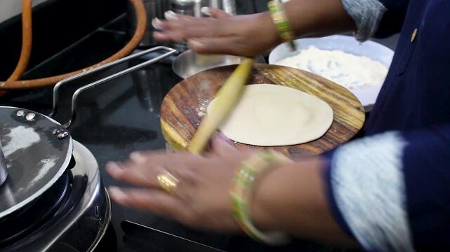 Closeup footage of hands rolling fresh roti dough in an Indian kitchen, ideal for homemade food, cooking culture, culinary, and lifestyle projects.