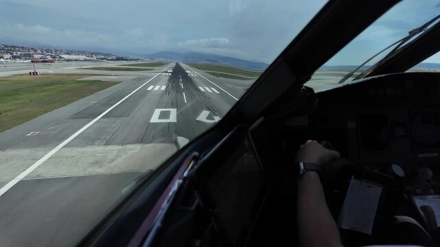 immersive pilot&rsquo;s view in a real time landing at Nice aiport through cockpit window, with a view of Captain&rsquo;s hand on the flight controls.