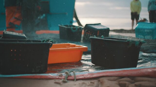 Fishermen unloading fresh catch in plastic baskets