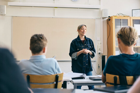 Female junior high school professor teaching students in classroom