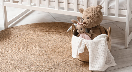 Wicker basket with toys on rug in children's room © Pixel-Shot