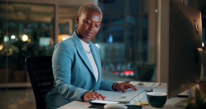 Black woman, computer and typing in office at night for research, finance chat and schedule update. African person, tech and communication for financial feedback, funding or offer for overtime