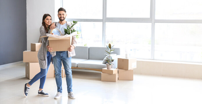 Young couple with belongings in their new house