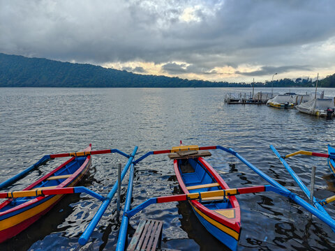 Traditional Outrigger Boats on Lake Bratan under Dramatic Stormy Sky in Bali