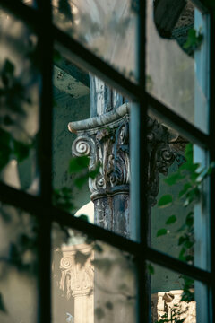 Classical Column Seen Through Old Window in Abandoned Sanatorium