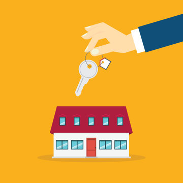 Hand holding key over the house. House buying