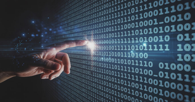 Hand interacting with binary code on a digital screen