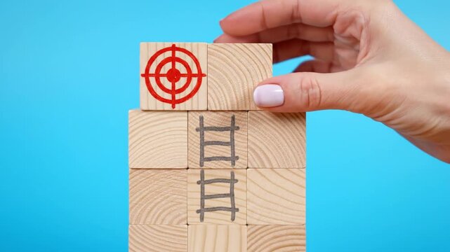 Goal achievement concept with wooden blocks and target icon