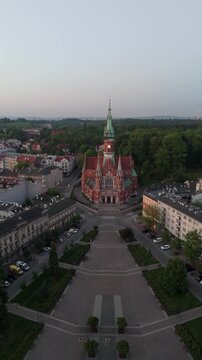 An aerial flyover over Krakow's Old Town square with a view of St. Joseph's Cathedral in springtime in Poland.