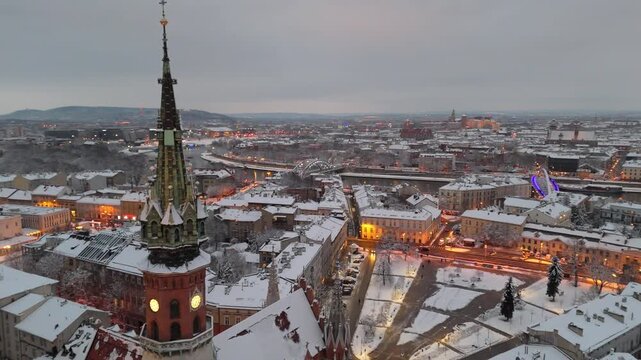Aerial flyover of St. Joseph's Cathedral in Krakow and the Old Town at sunset in winter