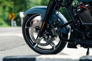 Obraz premium Close up of motorcycle front wheel with shiny disc brake and sleek tire on sunny day