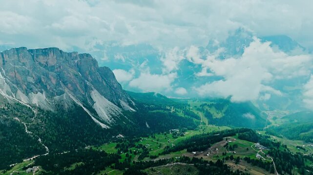 Aerial view of Seceda plateau with green alpine meadows, scattered huts and winding trails. Dolomites landscape