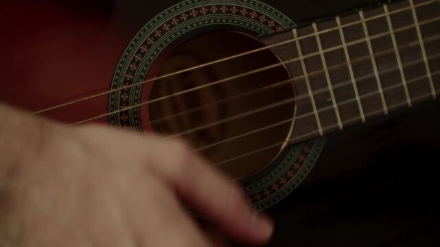 A detailed closeup shot of a musicians hand strumming a classic acoustic guitar, capturing authentic movement and artistic expression.