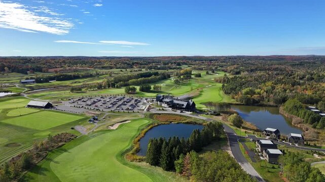 Sweeping aerial view of TPC Toronto's golf course with vibrant fall foliage and clear blue skies. Ideal for travel promotions and golf-related content.