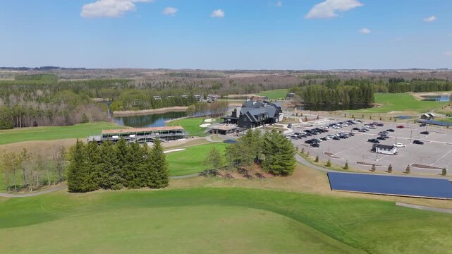 TPC Toronto at Osprey Valley Golf Course showcasing the clubhouse, parking area, and lush green fairways. Ideal for golf tourism and real estate marketing.