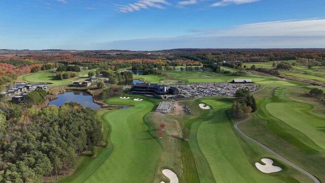 TPC Toronto at Osprey Valley with vibrant fall foliage. The clubhouse, parking area, and golf greens are visible. Suitable for travel promos or real estate showcases.