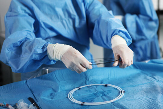 Removal of blood clots through small holes. Vascular endovascular surgery. The surgeon's hands. Surgical interventions on blood vessels. The concept of healthcare.