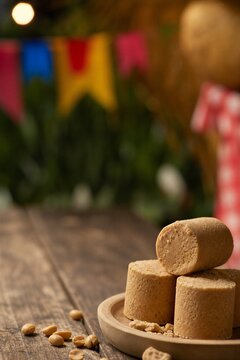 Traditional Brazilian Pa oca, a sweet peanut candy, served on a rustic wooden plate for Festa Junina celebration.
