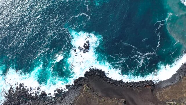 Top-down aerial view of Capelinhos Volcano coastline with Atlantic waves crashing on volcanic rocks, Faial Island, Azores