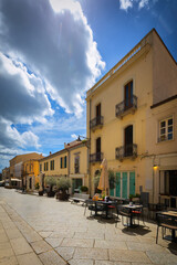 Obraz premium Narrow cobblestone street with colorful buildings in Olbia, Sardinia, Italy - background or travel wallpaper