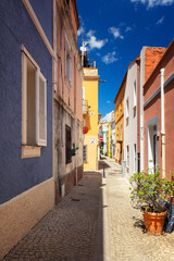 Fototapeta premium Narrow cobblestone street with colorful buildings in Olbia, Sardinia, Italy - background or travel wallpaper