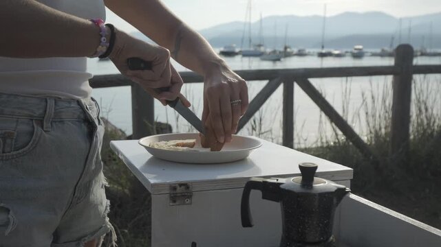 Cutting bread for breakfast in van life setting, Italy