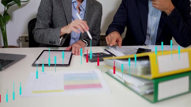 Financial advisors analyzing cryptocurrency candlestick chart on a tablet, forecasting market trends, and developing investment strategies for their portfolio
