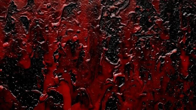 Red liquid dripping over dark textured background. Creepy horror theme with viscous fluid flow. Scary cinematic grunge backdrop for thriller and crime concept.