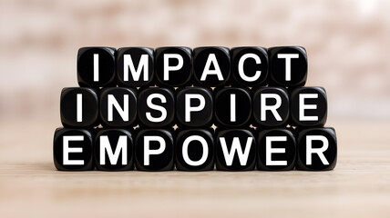 Obraz premium A motivational concept of impact, inspire, and empower on black beads