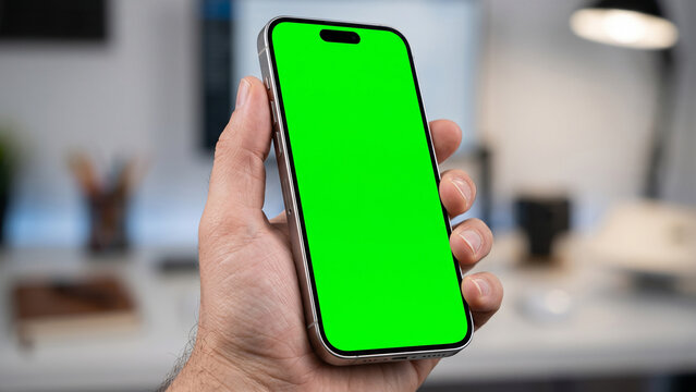 Hand holding smartphone with green screen mockup