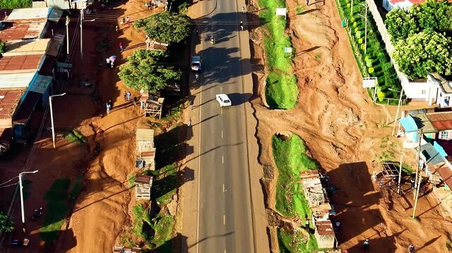kenya roads, rural roads, poor rural settlement, damaged road with drone tracking vehicles over the road in the air.