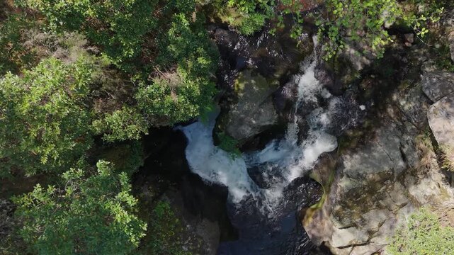Above View Of Cachon Waterfall Through Rock Boulders In Galicia, Spain. Aerial Descending Shot