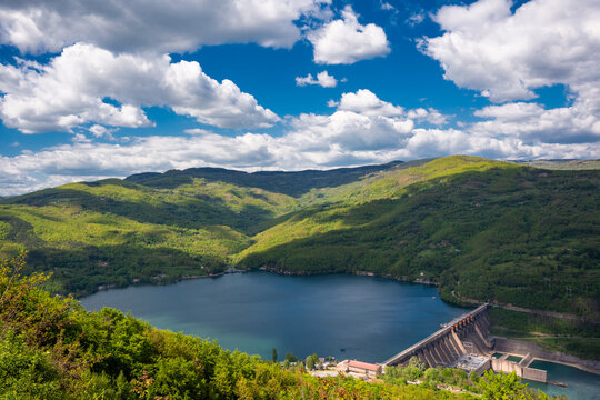 High angle view of the concrete hydroelectric dam on Perucac Lake surrounded by green mountains. Perucac, Bajina Basta, Serbia