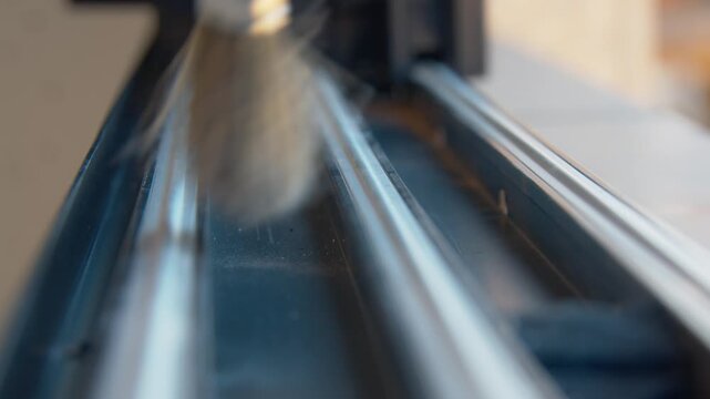 Close up of person cleaning window track with small brush indoors.