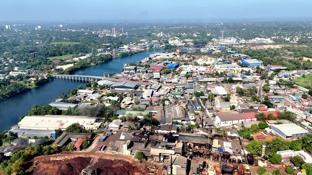 Wide cinematic aerial of Pathalam Regulator showcasing river infrastructure, industrial landscapes, and tropical urban surroundings blending modern development with natural waterways.