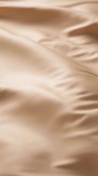 Soft beige satin fabric waves close up for luxury textile background