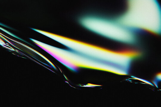 Abstract holographic background with colorful light refraction on liquid surface.