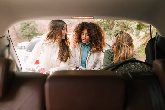 Friends packing car trunk for winter mountain hiking trip