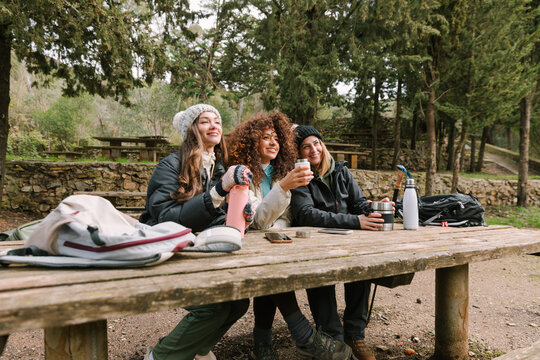 Winter mountain hiking friends relaxing at picnic table
