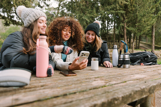 Winter hikers sharing a phone during mountain trail break