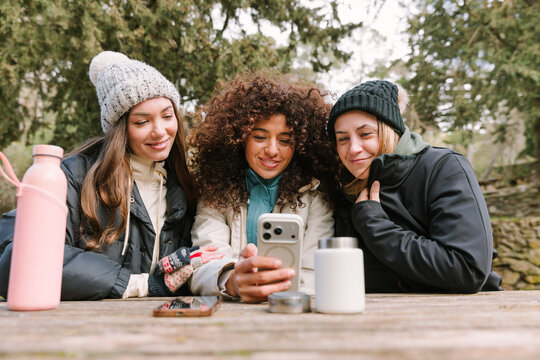 Winter hikers sharing smartphone moment at mountain rest stop